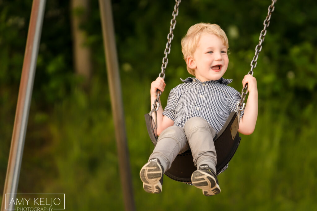 Young boy on swing at at Lincoln Park in West Seattle