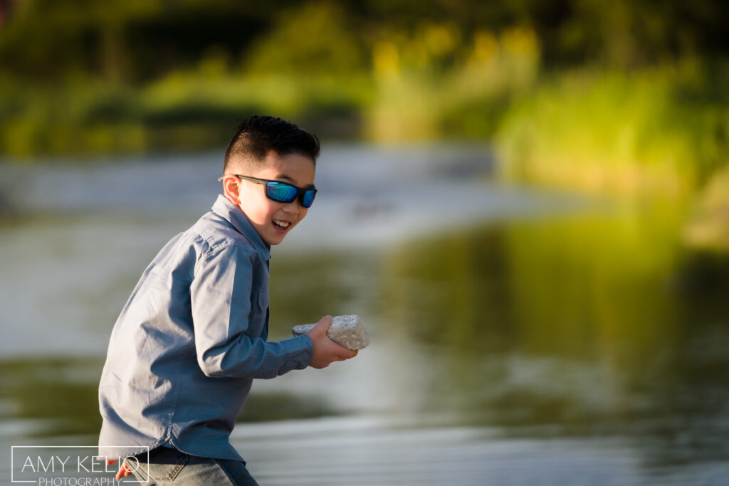 Young boy throwing rocks on beach at Carkeek Park in Seattle