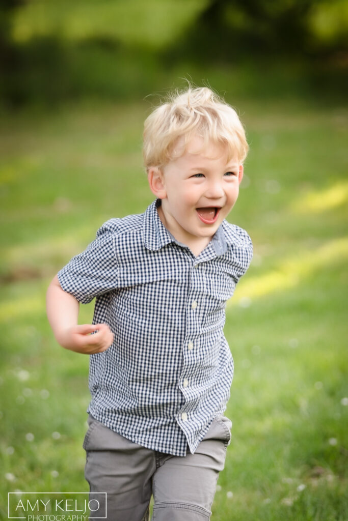 Young boy running on grass at Lincoln Park in West Seattle