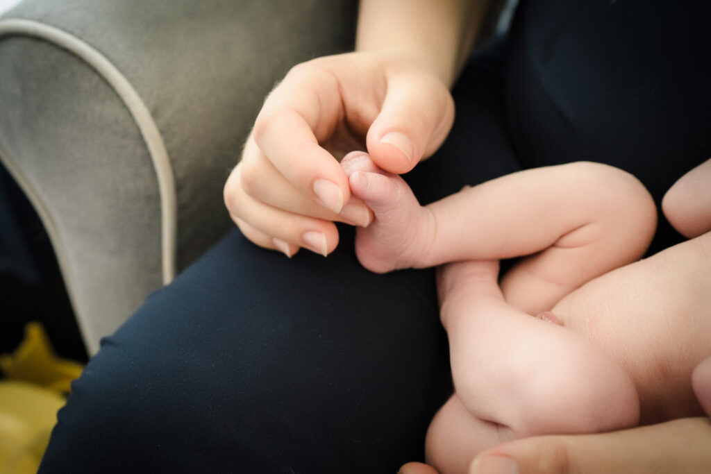 Mother holding newborn son's feet