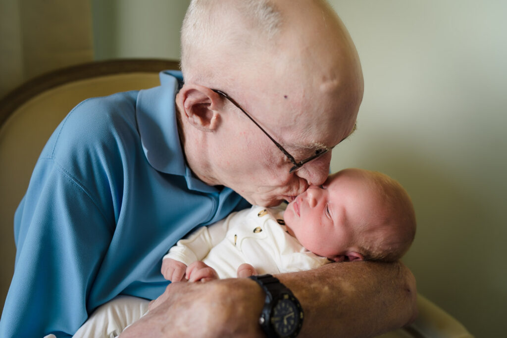 Grandfather holding his newborn grandchild at home photoshoot in Seattle