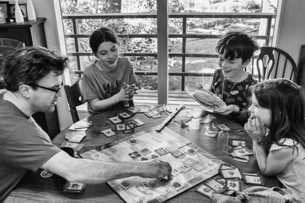 Documentary family photography of family playing board game together